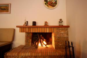 a brick fireplace with a fire in it at 7hills Waterfall Lodge by Ski Alure in Eptalofos