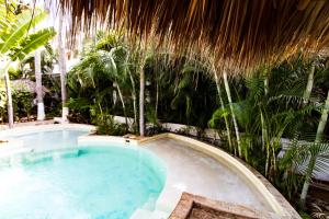 a swimming pool in a resort with palm trees at HiddenPort VHouse in Brisas de Zicatela +9 photos