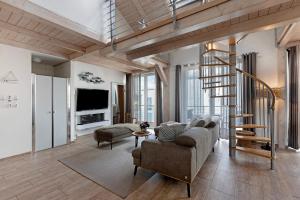 a living room with a staircase and a couch and chair at Fewo Seeschwalbe - Marina Mücheln in Mücheln