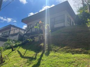 a house on top of a grassy hill at Villa Nogueira in Araras Petropolis