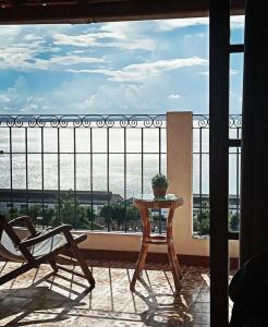 a table and chair on a balcony with a view at Pousada Beija Flor in Salvador
