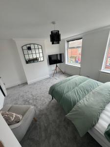 a bedroom with a bed and a chair and a television at The perfect room to rent in Altofts