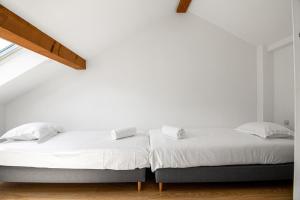 a white bedroom with a bed with white sheets at Sweet-mane in Roeser +6 photos