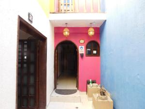 a hallway of a building with a pink and blue wall at Casona Luciérnaga-Casa de Huéspedes Centro de León, Poliforum in León