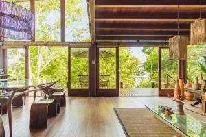 an open living room with a table and chairs at A Casinha da Floresta in Gamboa