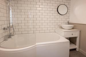 a white bathroom with a tub and a sink at Rhubarb Cottage in Chapel Stile +11 photos