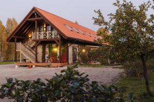 a log cabin with a porch and a deck at Karlamuiza Country Hotel in Kārļi