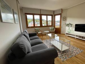 a living room with a couch and a glass table at Los Balcones de Vega in Vega de Espinareda