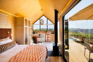 a bedroom with a bed and a large window at Stellenbosch Farm Cabin - Klein Frans in Stellenbosch