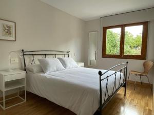a bedroom with a bed and a window and a chair at Los Balcones de Vega in Vega de Espinareda