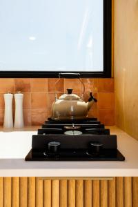 a tea pot sitting on top of a stove at Stellenbosch Farm Cabin - Klein Frans in Stellenbosch +13 photos