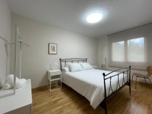 a white bedroom with a bed and a window at Los Balcones de Vega in Vega de Espinareda +20 photos