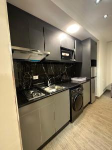 a kitchen with a stove and a sink at central apartment for rent 22 in Amman +6 photos