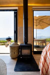 a wood stove in a room with a view of a patio at Stellenbosch Farm Cabin - Klein Frans in Stellenbosch