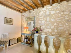 a room with a stone wall with a table and a sink at Maison St. Clair in Monflanquin