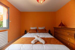 a bedroom with a bed with an animal laying on it at La Petite Maison Gannat in Gannat