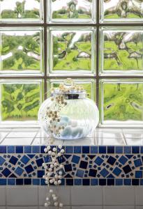 a glass vase sitting on a counter in a bathroom at La Petite Maison Gannat in Gannat