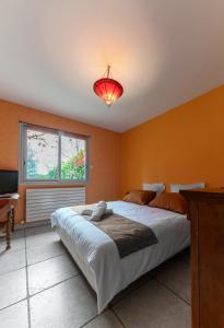 a bedroom with a large bed and a red light at La Petite Maison Gannat in Gannat