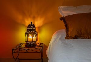 a lamp on a table next to a bed at La Petite Maison Gannat in Gannat +42 photos