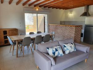 a living room with a couch and a table at La Bergerie in Saigneville +9 photos