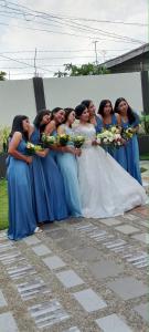 a group of women in blue dresses holding bouquets at Villa Cresenciana in Batuan