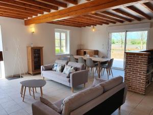 a living room with couches and a table and a dining room at La Bergerie in Saigneville