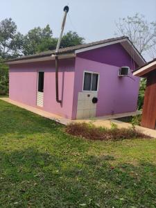 a pink and purple house with a yard at Casa mobiliada privativa in Caiçara