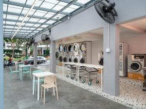 a room with tables and chairs and washing machines at Wash House Chatuchak in Bangkok