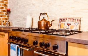 a tea kettle sitting on top of a stove in a kitchen at Blue Hound Cottage in Kaunas