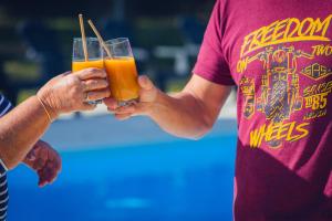 two people holding up glasses of orange juice at L'Oasis des Dombes in Ambérieux-en-Dombes