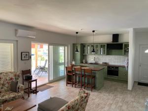 a kitchen with green cabinets and a table and chairs at Villa hygge in Šibenik