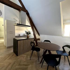 a dining room with a table and chairs and a kitchen at Duplex design - 6 personnes - Charleville-Mézières in Charleville-Mézières