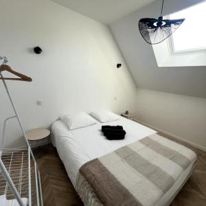 a bedroom with a bed with a black bag on it at Duplex design - 6 personnes - Charleville-Mézières in Charleville-Mézières