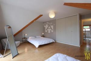 ein Schlafzimmer mit zwei Betten und einem Spiegel in der Unterkunft Rev'O'Lac 2 in Chambon-sur-Lac