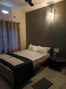 a bedroom with a large bed and a table at Coorg wildstone Homestay in Madikeri +3 photos
