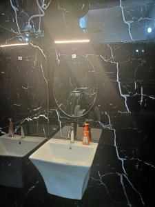 a black bathroom with a sink and a mirror at Coorg wildstone Homestay in Madikeri