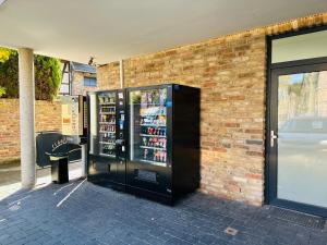 a soda vending machine on the side of a brick building at Doppelzimmer 4 in Pulheim