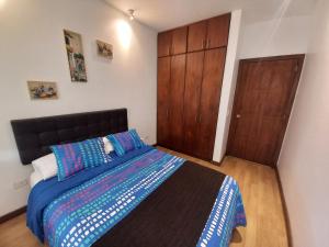 a bedroom with a bed and a wooden door at Apartamento en el CENTRO HISTÓRICO DE QUITO in Quito