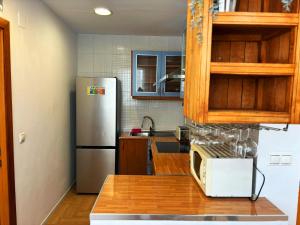 a kitchen with a stainless steel refrigerator and wooden cabinets at Encantador piso en Benimaclet in Valencia