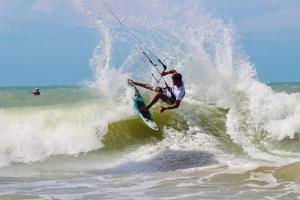 a man riding a wave on a surfboard in the ocean at Vila Almar in Taíba