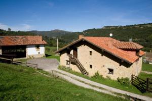 a large stone building with a red roof at Primorías Camijanes in Camijanes