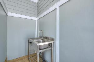 ein Waschbecken in einem Zimmer mit einer weißen Wand in der Unterkunft Fishy Fishy Down in Oak Island + 36 Fotos