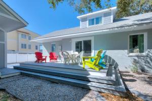 ein Haus mit einer Veranda mit bunten Stühlen darauf in der Unterkunft Fishy Fishy Down in Oak Island