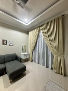 a living room with a couch and a window at Homestay Pulau Serai in Kampong Nibong +32 photos