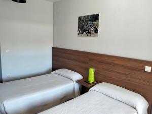 ein Hotelzimmer mit 2 Betten und einem Bild an der Wand in der Unterkunft Hostal La Estación in Avila