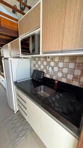 a kitchen with a sink and a stove and cabinets at Bangalô com tudo privativo em Tamandaré/PE in Tamandaré