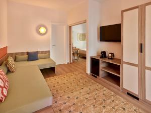 a living room with a couch and a television at Calaserena Resort in Geremèas