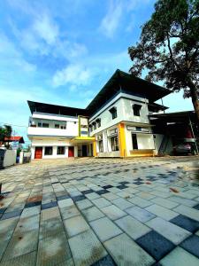 ein großes weißes Gebäude mit einem schwarzen Dach in der Unterkunft kollam Beach Resort in Kollam + 9 Fotos