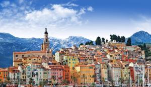 a town on a hill with mountains in the background at Menton: superbe appartement in Menton