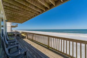 a balcony with chairs and a view of the beach at Beachfront Vilano Retreat in Saint Augustine